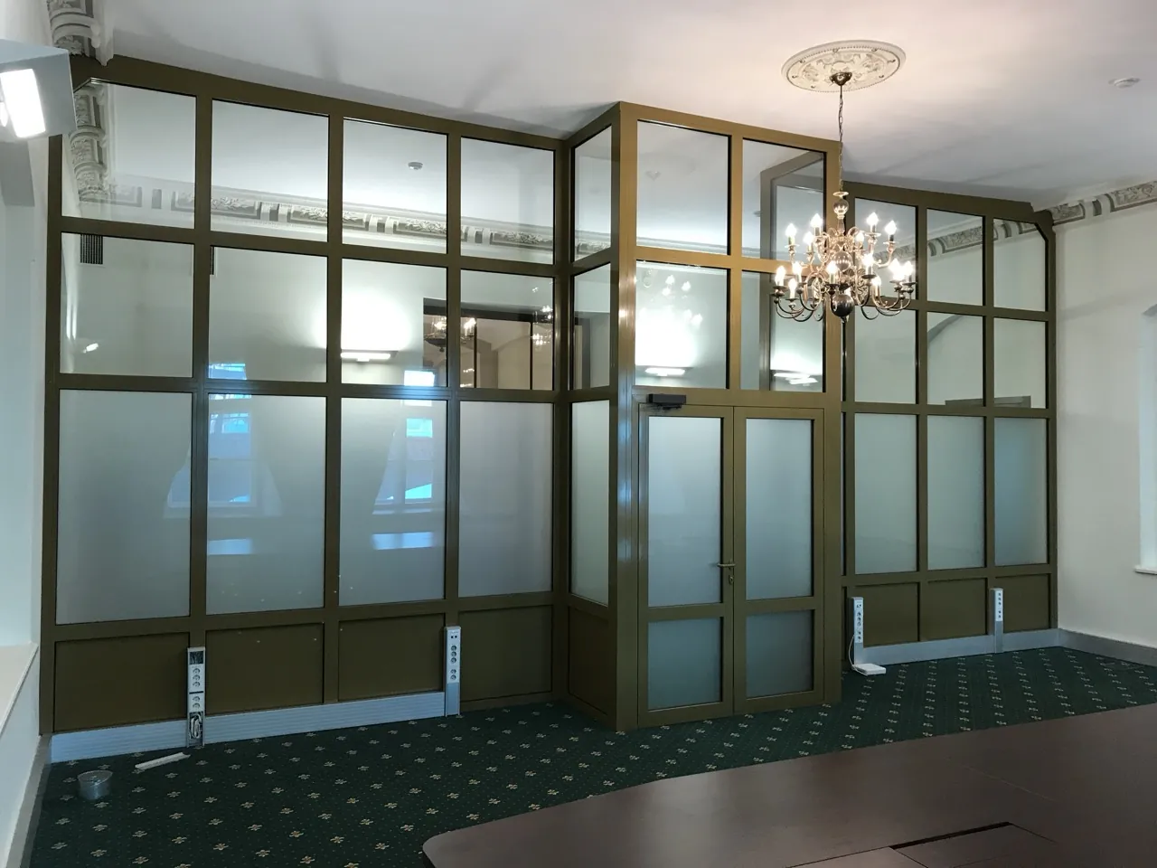 Glazed partition wall installed within a heritage interior, linking old and new spaces